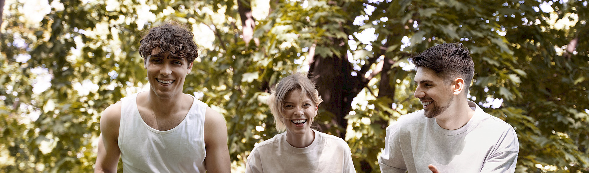 Drei junge Menschen wärmen sich im Wald auf