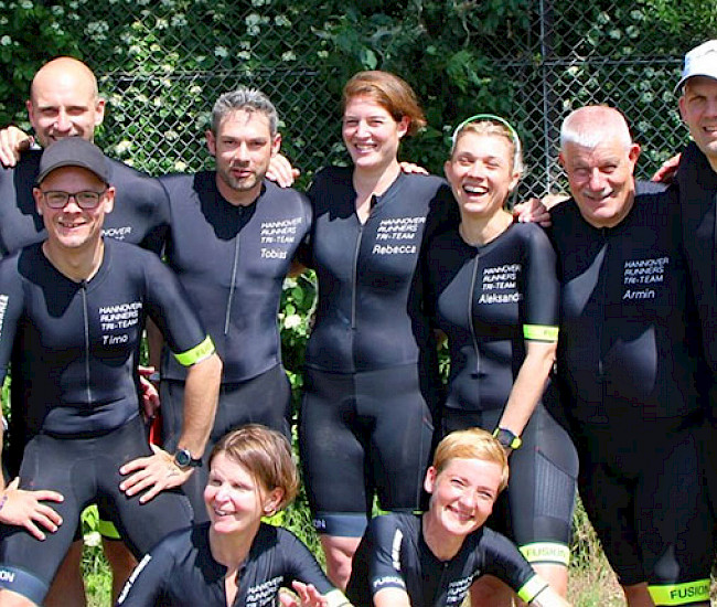 Mitglieder des Hannover Runners e.V. in Neoprenanzügen stehen zusammen