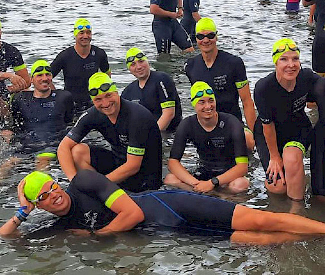 Mitglieder des Hannover Runners e.V. in Schwimmbekleidung posieren im Wasser
