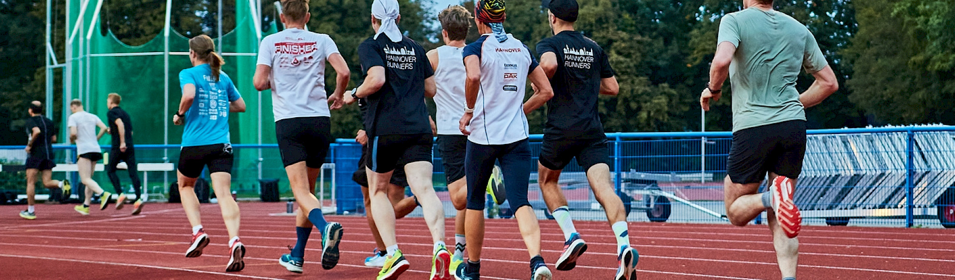 Eine Gruppe an Läufern von den Hannover Runners joggen auf einer Laufstrecke