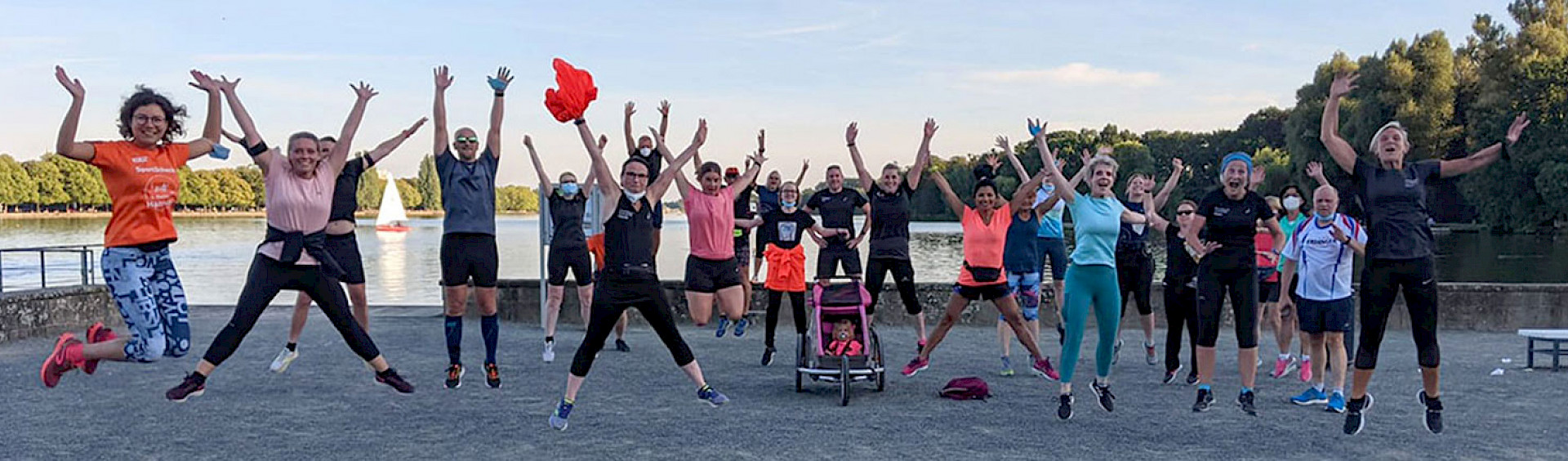 Einige Teilnehmer des Donnerstags-Schnecken-Lauftreffs springen erfreut in die Luft und strecken ihre Arme nach oben